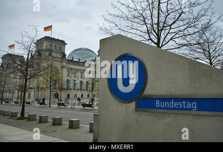 Berlino, Germania - 14 Aprile 2018: uscita del Bundestag U-Bahn stazione della metropolitana con road, alberi sfrondato e Edificio del Reichstag sullo sfondo Foto Stock