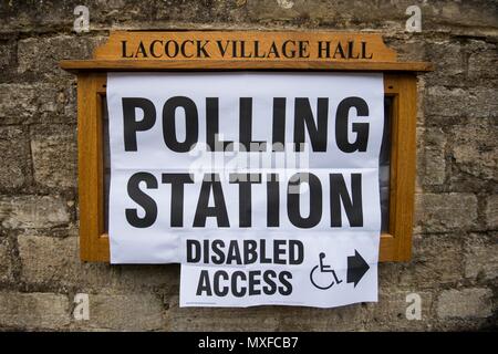 La gente va a poli nell'elezione generale 2017 foto di un conservatore teller sorge al di fuori della stazione di polling a Lacock Village Hall Foto Stock