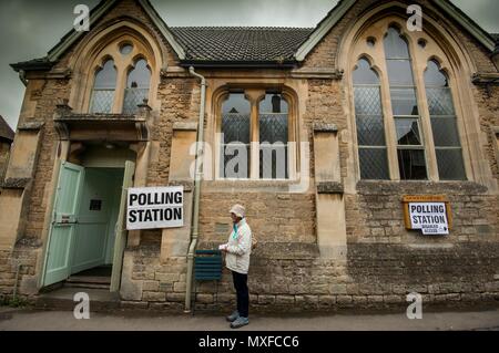 La gente va a poli nell'elezione generale 2017 foto di un conservatore teller sorge al di fuori della stazione di polling a Lacock Village Hall Foto Stock