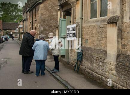 La gente va a poli nell'elezione generale 2017 foto di un conservatore teller sorge al di fuori della stazione di polling a Lacock Village Hall Foto Stock