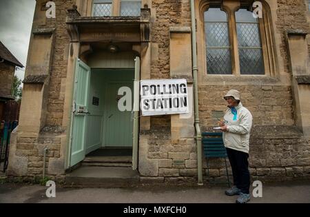 La gente va a poli nell'elezione generale 2017 foto di un conservatore teller sorge al di fuori della stazione di polling a Lacock Village Hall Foto Stock