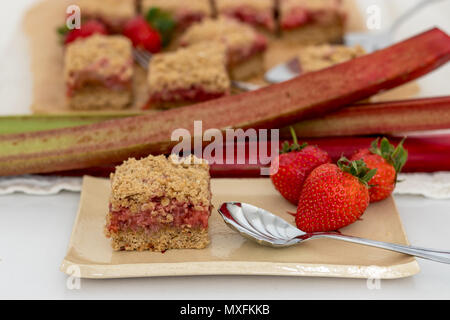 Fette di sani di rosso frutta estiva bar servita su un handmade piastra ceramica. Un delizioso pane appena sfornato dolci con fragole e rabarbaro. Foto Stock