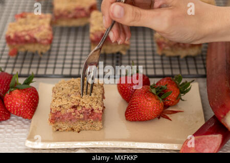 Fette di sani di rosso frutta estiva bar servita su un handmade piastra ceramica. Un delizioso pane appena sfornato dolci con fragole e rabarbaro. Foto Stock