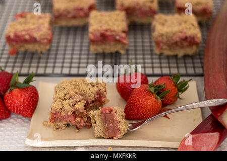 Fette di sani di rosso frutta estiva bar servita su un handmade piastra ceramica. Un delizioso pane appena sfornato dolci con fragole e rabarbaro. Foto Stock