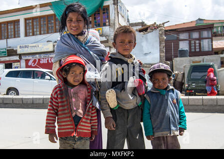 Poveri bambini con fratelli più giovani che pregano di turisti per le strade di Leh in Ladakh. India luglio 2015 Foto Stock