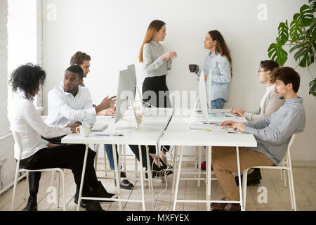 Le persone che lavorano a fare tante cose diverse in coworking office Foto Stock