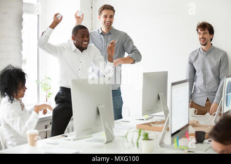 Positivo il team multirazziale divertirsi lanciando palle di carta Foto Stock