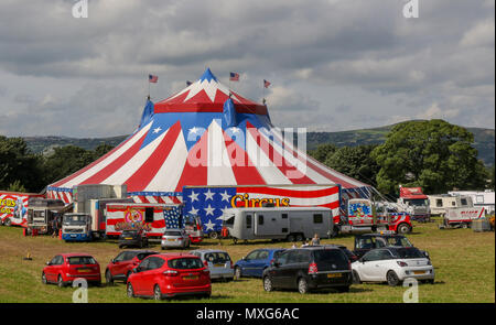 Circus Vegas, un circo che tour nel Regno Unito e in Irlanda si accamparono in un campo a fianco di roulotte e auto parcheggiate. Foto Stock