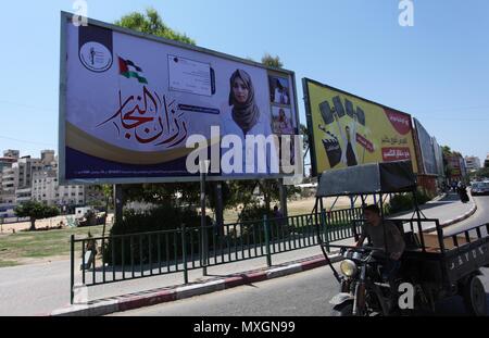 4 giugno 2018 - Gaza City, nella Striscia di Gaza, Territori palestinesi - i palestinesi a piedi passato un murale raffigurante un infermiere Razan Al-Najar, che è stato ucciso dai soldati israeliani, durante una manifestazione di protesta al confine Israel-Gaza, nella Striscia di Gaza City il 4 giugno 2018. Razan Al-Najarâ€™s morte portato a 119 il numero di palestinesi uccisi in dimostrazioni settimanale lanciato il 30 marzo nella Striscia di Gaza (credito Immagine: © Mahmoud Ajour/APA immagini via ZUMA filo) Foto Stock