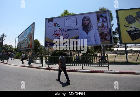4 giugno 2018 - Gaza City, nella Striscia di Gaza, Territori palestinesi - i palestinesi a piedi passato un murale raffigurante un infermiere Razan Al-Najar, che è stato ucciso dai soldati israeliani, durante una manifestazione di protesta al confine Israel-Gaza, nella Striscia di Gaza City il 4 giugno 2018. Razan Al-Najarâ€™s morte portato a 119 il numero di palestinesi uccisi in dimostrazioni settimanale lanciato il 30 marzo nella Striscia di Gaza (credito Immagine: © Mahmoud Ajour/APA immagini via ZUMA filo) Foto Stock