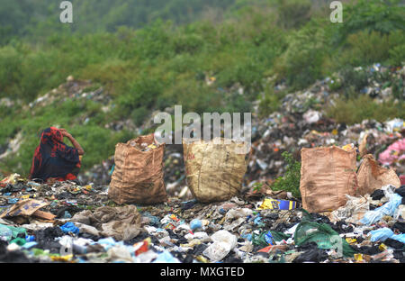 Dimapur, India - 4 Giugno 2018: una donna Indiana ragpicker sedersi accanto al sacchetto di voce di riciclo raccolti per ri-uso da un sito di dumping alla vigilia della Giornata Mondiale dell Ambiente in Dimapur, India nord orientale di stato del Nagaland. La Giornata Mondiale dell Ambiente è Marco annualmente in giugno5 con il tema di quest'anno come 'Beat inquinamento plastica". Credito: Caisii Mao/Alamy Live News Foto Stock