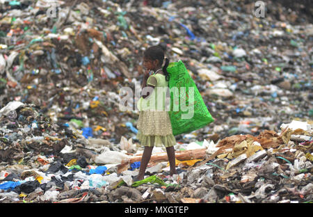 Dimapur, India - 4 Giugno 2018: un bambino indiano ragpicker guarda tra cumuli di rifiuti come lei raccogliere nuovamente gli elementi utilizzabili da un sito di dumping alla vigilia della Giornata Mondiale dell Ambiente in Dimapur, India nord orientale di stato del Nagaland. La Giornata Mondiale dell Ambiente è Marco annualmente in giugno5 con il tema di quest'anno come 'Beat inquinamento plastica". Credito: Caisii Mao/Alamy Live News Foto Stock