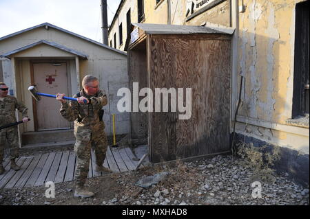 Aviosuperficie di Bagram, Afghanistan (nov. 9, 2016) - USA Esercito Col. G. Shawn Pozzi, Jr., Area Support Group - Afghanistan comandante maneggia una mazza in un cerimoniale di prima oscillazione nella demolizione di Bagram Airfield Edificio 960, il più di sessant anni di vecchio impianto che ha ospitato U.S. Esercito MEDEVAC unità aerea da più di un decennio. Col. John M. Cyrulik, 1° Combt Aviation comandante di brigata è visibile a sinistra. Foto di Bob Harrison, U.S. Forces Afghanistan affari pubblici. Foto Stock