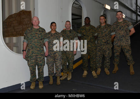 FORT LAUDERDALE, FLORIDA -- Il II Marine forza expeditionary leadership, il Mag. Gen. Walter L. Miller Jr., Sgt. Il Mag. Richard D. la trebbiatrice e il comando Master Chief Russell W. Folley, stand con un gruppo di Marines il 5 maggio 2017 nei pressi di un oblò sulla USS New York che fornisce un punto di vista di un foglio di acciaio dal World Trade Center. La USS New York, un San Antonio-classe di trasporto anfibio dock, è stato chiamato dopo lo stato di New York e ha molti promemoria degli attacchi dell'11 settembre; includente un Fire Fighters camicia da uno degli uomini che erano sulla scena. La nave è il motto che è "strenght per Foto Stock