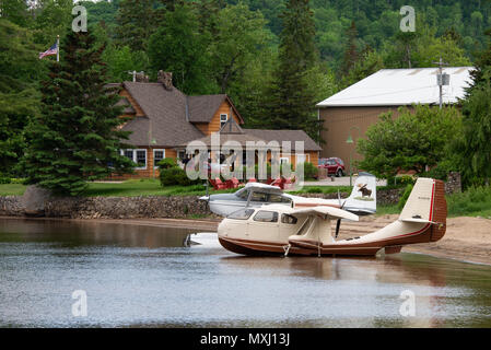 Due idrovolanti, una repubblica RC-3 e un Cessna 180J legato sulla spiaggia sul lago piacevole in speculatore, NY davanti al Lago Pleasant Lodge. Foto Stock