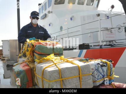 Coast Guard trasferita la custodia dei due sospetti di contrabbandieri e più balle di cocaina alla legge federale alle autorità incaricate di far rispettare la legge a Coast Guard Settore San Juan a San Juan, Puerto Rico nov. 10, 2016. In totale, 1.158 libbre di cocaina con una stima di valore all'ingrosso di $13.1 milioni di euro sono stati sequestrati come risultato multi-agenzia legge gli sforzi a sostegno dell'operazione Unified risolvere e funzionamento dei Caraibi di protezione. (U.S. Coast Guard foto di Ricardo Castrodad) Foto Stock