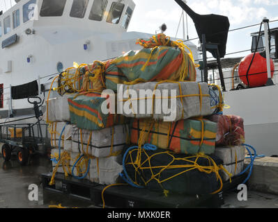 Coast Guard trasferita la custodia dei due sospetti di contrabbandieri e più balle di cocaina alla legge federale alle autorità incaricate di far rispettare la legge a Coast Guard Settore San Juan a San Juan, Puerto Rico nov. 10, 2016. In totale, 1.158 libbre di cocaina con una stima di valore all'ingrosso di $13.1 milioni di euro sono stati sequestrati come risultato multi-agenzia legge gli sforzi a sostegno dell'operazione Unified risolvere e funzionamento dei Caraibi di protezione. (U.S. Coast Guard foto di Ricardo Castrodad) Foto Stock