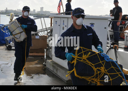 Coast Guard trasferita la custodia dei due sospetti di contrabbandieri e più balle di cocaina alla legge federale alle autorità incaricate di far rispettare la legge a Coast Guard Settore San Juan a San Juan, Puerto Rico nov. 10, 2016. In totale, 1.158 libbre di cocaina con una stima di valore all'ingrosso di $13.1 milioni di euro sono stati sequestrati come risultato multi-agenzia legge gli sforzi a sostegno dell'operazione Unified risolvere e funzionamento dei Caraibi di protezione. (U.S. Coast Guard foto di Ricardo Castrodad) Foto Stock