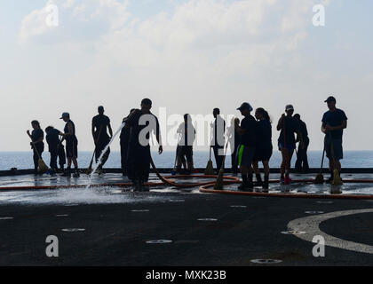 161111-N-TI017-056 Golfo di Aden (nov. 11, 2016) marinai lavi giù il ponte di volo del dock anfibio sbarco nave USS Whidbey Island (LSD 41) con acqua fresca. Whidbey Island viene distribuito con la Vespa Anfibia gruppo pronto per supportare le operazioni di sicurezza marittima e di teatro la cooperazione in materia di sicurezza gli sforzi negli Stati Uniti Quinta Flotta area di operazioni. (U.S. Navy foto di Sottufficiali di 2a classe di Nathan R. McDonald/rilasciato) Foto Stock