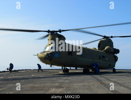 161110-N-TI017-174 Golfo di Aden (nov. 10, 2016) marinai Rimuovere tacchi e catene da una U.S. Esercito CH-47 elicottero Chinook sul ponte di volo del dock anfibio sbarco nave USS Whidbey Island (LSD 41). Whidbey Island viene distribuito con la Vespa Anfibia gruppo pronto per supportare le operazioni di sicurezza marittima e di teatro la cooperazione in materia di sicurezza gli sforzi negli Stati Uniti Quinta Flotta area di operazioni. (U.S. Navy foto di Sottufficiali di 2a classe di Nathan R. McDonald/rilasciato) Foto Stock