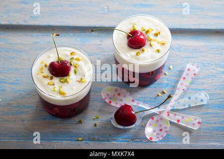 Gelatina di ciliegie con crema di pistacchio e ciliegia sulla sommità del dessert Foto Stock