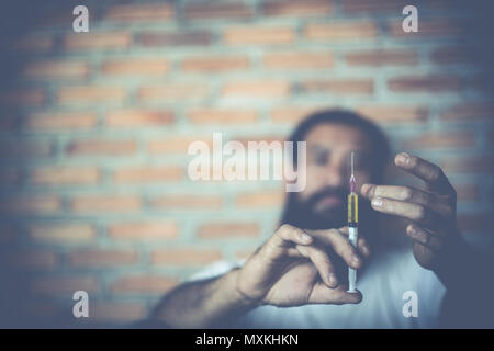 Tossicodipendente uomo con siringa tramite, farmaci concetto. Foto Stock