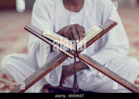 Musulmani africani uomo rendendo tradizionale preghiera a Dio indossando Dishdasha Foto Stock