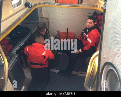 Coast Guard il suo equipaggio a bordo di un 45-piede barca di risposta dalla stazione della Guardia Costiera punto Judith, in Rhode Island, a fornire le prime cure mediale di un windsurf Mercoledì, Novembre 16, 2016 dopo aver salvato la sua dalle rocce vicino al punto Judith porto di rifugio. Una superficie nuotatore distribuita da 45 piedi barca risposta per aiutare a ottenere il suo sicuro a bordo della Guardia Costiera imbarcazione. (U.S. Coast Guard foto di Sottufficiali di terza classe Dannion Hollar) Foto Stock