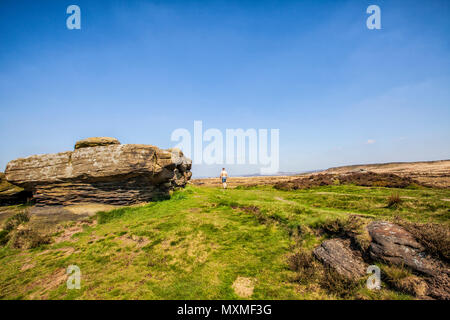 Uomo solitario camminando sul bordo Curbar, Parco Nazionale di Peak District, Derbyshire, Inghilterra 2018 Foto Stock