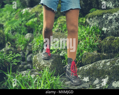 Le gambe di una giovane donna che indossa scarpe da trekking in natura Foto Stock