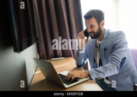 Imprenditore lavora su computer in camera di albergo Foto Stock