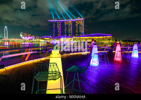 Singapore - Aprile 28, 2018: Marina Bay Sands con luci colorate durante il laser show vista dal tetto del padiglione Fullerton, ristorante italiano Monti a 1-Pavilion nel porto di Singapore di notte. Foto Stock