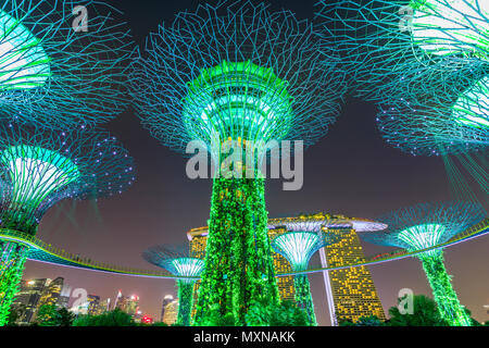 Singapore - Aprile 30, 2018: Giardino Rhapsody luce e suono mostra su Supertree Grove con OCBC Skyway presso i giardini della baia. Il Marina Bay Sands sullo sfondo. Popolare attrazione turistica. Illuminazione verde. Foto Stock