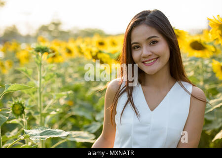 Giovani felici bella asiatica donna sorridente nel campo dell'bloomi Foto Stock