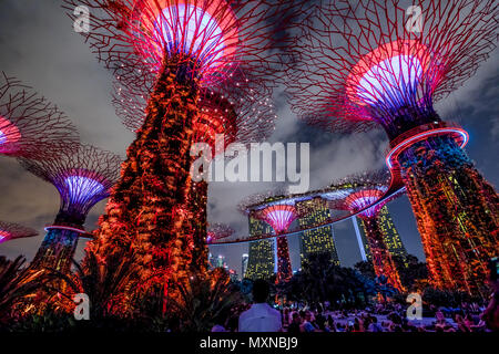 Singapore - Aprile 30, 2018: Giardino Rhapsody luce e suono mostra su Supertree Grove con OCBC Skyway presso i giardini della baia. Il Marina Bay Sands sullo sfondo. Popolare attrazione turistica. Illuminazione rossa. Foto Stock