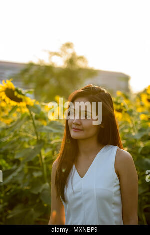 Giovane bella donna asiatica pensare osservando la distanza i Foto Stock