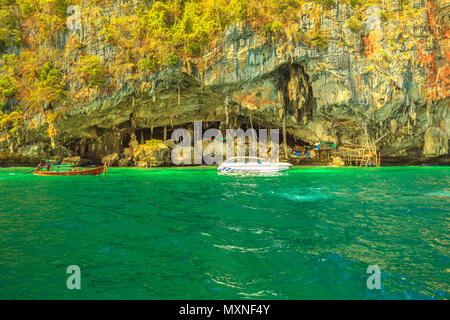 Barche visita Grotta Vichinga, a nord di Piley Bay, una delle principali attrazioni turistiche di Ko Phi Phi Leh, vicino a Maya Bay, le Isole Phi Phi, Thailandia. All'interno della grotta ci sono migliaia di si accoccola di rondoni. Foto Stock