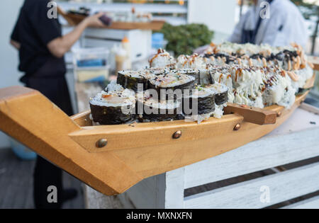 Crostini: assortimento di sushi rotoli essendo servita su una barca di legno Foto Stock