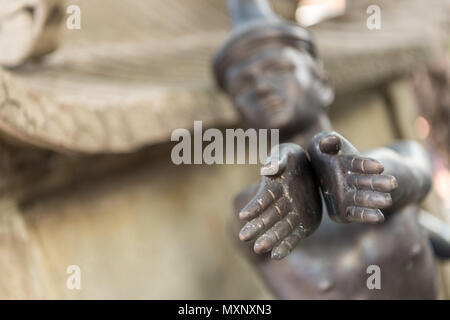 Una statua di bronzo che illustra il massaggio di rilassamento snd presso il Wat Pho tempio del Buddha recloning Bangkok, Thailandia Foto Stock