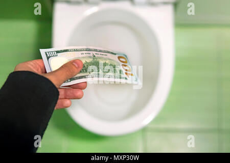 Lavare il denaro verso il basso il wc, genera le fatture del dollaro nella toilette, perdita concetto, vicino il fuoco selettivo. concetto di assurdo spreco di denaro, perdita, us