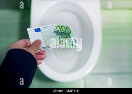 Concetto di assurdo spreco di denaro, perdita inutile spreco, grandi costi di acqua, rifiuti del concetto di denaro con euro bill e wc. perdita di denaro, perdendo m Foto Stock