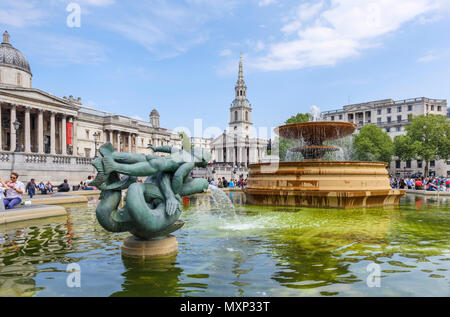 Mermaid statua in fontane a Trafalgar Square, Westminster central London WC2 St Martin nei campi la chiesa e la Galleria Nazionale dietro Foto Stock