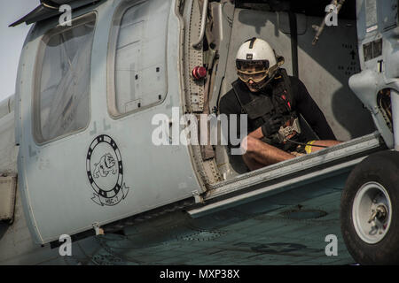 161123-N-RX777-281 GOLFO ARABICO (nov. 23, 2016) Petty Officer di terza classe Bretton Gilbert guida il pilota di un MH-60S Sea Hawk elicottero assegnato per il polveroso cani di elicottero di mare squadrone di combattimento (HSC) 7 durante un rifornimento verticale a bordo del combattimento veloce nave appoggio USNS Arctic (T-AOE 8). Artico è implementato il supporto di coalizione forze marittime navi negli Stati Uniti Quinta Flotta area di operazioni. (U.S. Navy foto di Sottufficiali di terza classe Cole Keller) Foto Stock