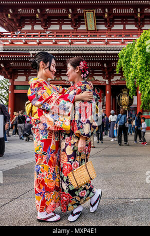 Due donne in tradizionali abiti giapponesi abbracciarsi teneramente nel Tempio di Senso-ji in Tokyo, Giappone Foto Stock