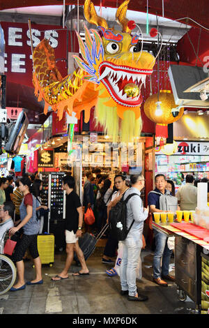 Singapore Bugis Street. Tra gli stretti corridoi di questo bilancio friendly mall, la folla di turisti e visitatori cercare occasioni e a buon mercato Offerte per lo shopping Foto Stock