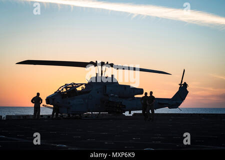 161114-N-DQ840-059 mare mediterraneo (nov. 14, 2016) Marines, dal 22 Marine Expeditionary Unit, ispezionare un AH-1W Super elicottero Cobra a bordo il trasporto anfibio dock nave USS San Antonio (LPD) 17 nov. 14, 2016. La ventiduesima MEU, imbarcato su San Antonio è in conduzione precision air scioperi a sostegno del governo libico di Accordo Nazionale-allineate le forze contro bersagli Daesh a Sirte, in Libia come parte di Operazione Odyssey fulmini. (U.S. Navy foto di Sottufficiali di 2a classe di Adam Austin/rilasciato) Foto Stock