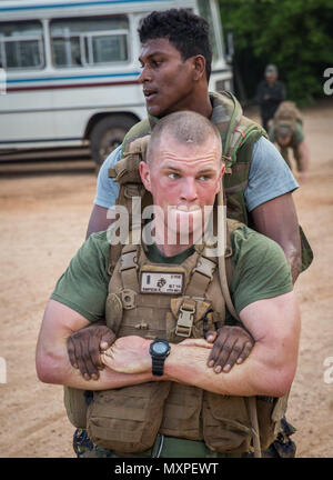 TRINCOMALEE, Sri Lanka (nov. 25, 2016) Una dello Sri Lanka marino "buddy" trascina 1Lt. Robert Simpson, un comandante di plotone con Alfa Co., battaglione atterraggio Squadra 1st Bn., 4 Marines, undicesimo Marine Expeditionary Unit, durante l'allenamento fisico durante un teatro la cooperazione in materia di sicurezza l'impegno a Sri Lanka Base Navale, Trincomalee, nov. 25, 2016. Entrambi gli Stati Uniti e il governo dello Sri Lanka Marines insegnato ogni altri stili diversi di militari fisica. Xi MEU, parte di Makin Island anfibio gruppo pronto, è operativo negli Stati Uniti 7 della flotta area di responsabilità a sostegno della sicurezza e della stabilità in In Foto Stock