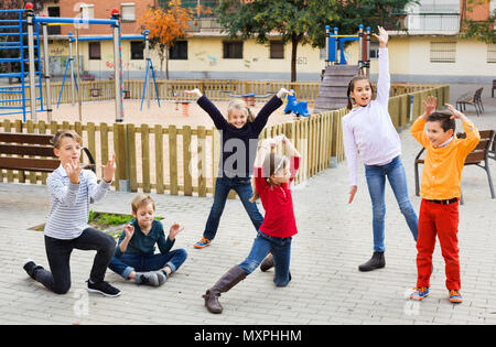 Deliberando gioco con felice allegro positivo ai bambini di prestazioni all'aperto in autunno Foto Stock