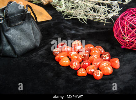 Rune arancione per la divinazione con gli attributi di magica sul tavolo closeup Foto Stock