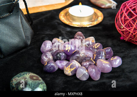 Rune per la divinazione con gli attributi di magica sul tavolo Foto Stock